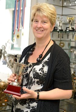 Proprietor Lisa holding trophy in the Hopmarket Trophies shop